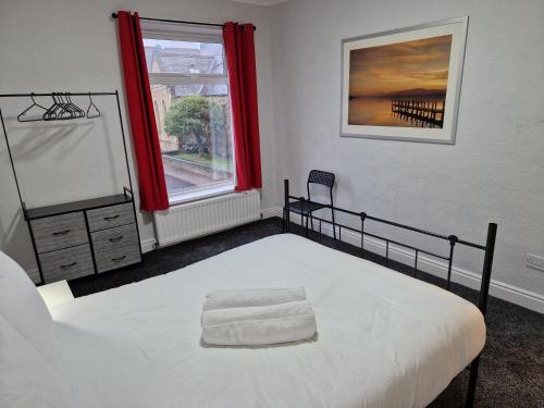 伯特利Birtley's Diamond 3 bed Apt, sleeps 6 Guests的一间卧室配有床和红色窗帘的窗户