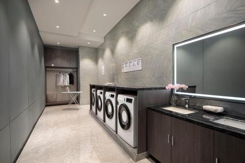 义乌义乌开臣K酒店的一间带3台洗衣机和水槽的浴室