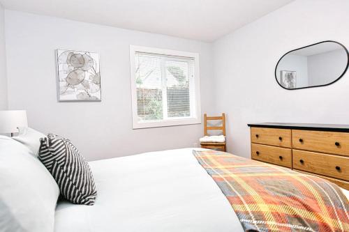维多利亚Esquimalt Lagoon Life的一间卧室配有一张床、梳妆台和镜子