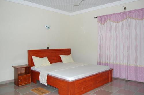 CococodjiMaison Verte a Cococodji的一间卧室配有一张床和粉红色窗帘