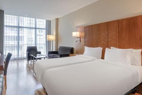 马德里艾塔纳万豪AC酒店的一张大白色的床,位于酒店客房内