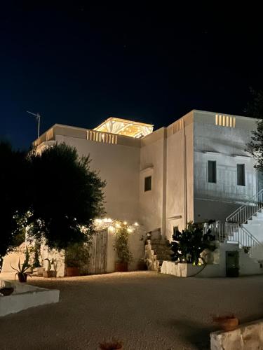 马鲁焦Casa alle Colonne的一座白色的大建筑,晚上有灯