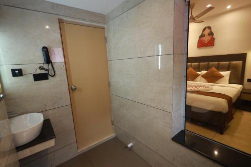 特里凡得琅Goodland Elegance的浴室设有床、水槽和镜子