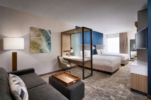 埃尔帕索SpringHill Suites by Marriott El Paso Airport的酒店客房设有一张沙发和一张床