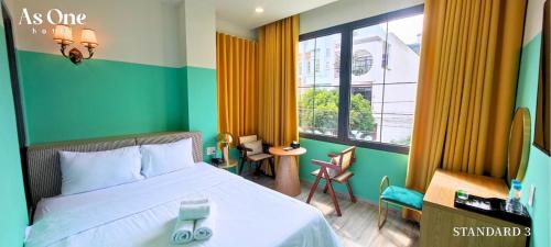 边和As ONE Hotel Biên Hòa的一间卧室设有一张床和一个大窗户