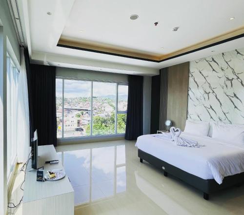 PinelengRogers Hotel Manado的一间卧室设有一张床和一个大窗户
