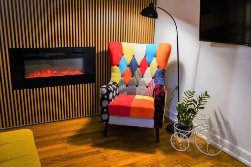 布泽特Stunning new apartment in centre of Buzet的客厅里设有五颜六色的椅子,配有壁炉