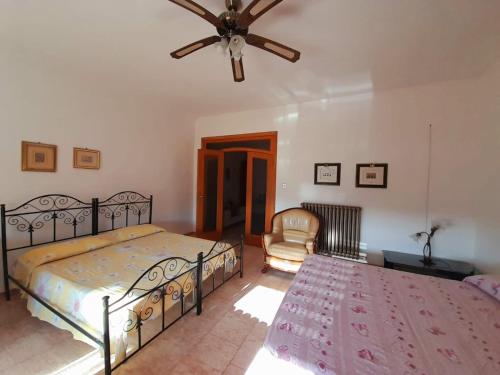 曼杜里亚Casa Maria的一间卧室配有两张床和吊扇