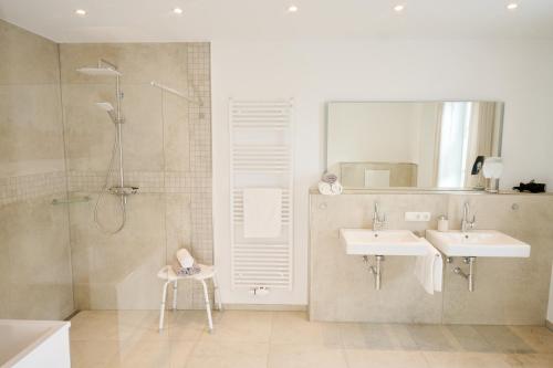 索尔陶Landhaus Eichengarten的带淋浴、两个盥洗盆和淋浴的浴室。