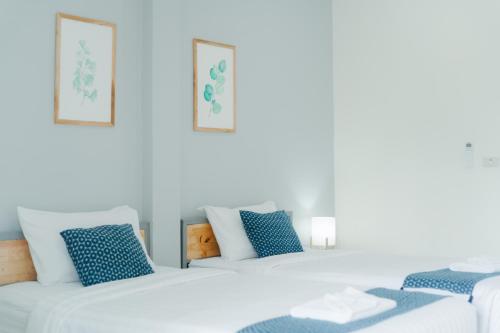 清莱Annahouse的蓝色枕头的房间里一排白色的床
