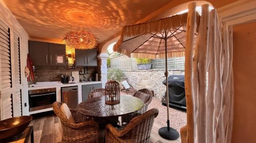 维琪奥港Chez Virginie的厨房配有桌椅和雨伞。