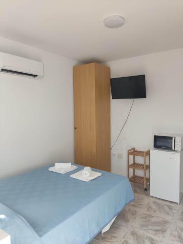 圣何塞Habitacion 1 o 2 personas的一间卧室配有蓝色的床和电视