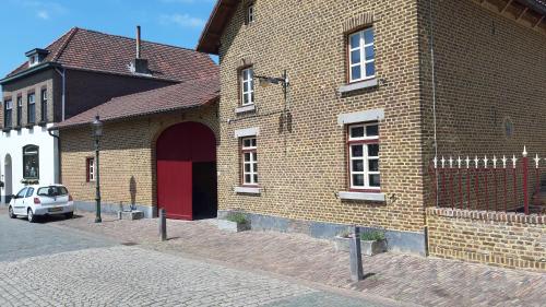 埃尔斯洛Boerderijwoning Elsloo的街上有红门的砖砌建筑