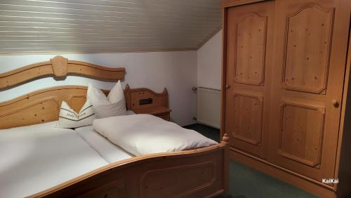 容霍尔茨Erd´s Hoimatle的卧室配有一张白色大床和木制床头板