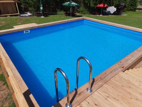 伊斯泰布纳Olza Karczma i pokoje的一座带金属栏杆的蓝色游泳池