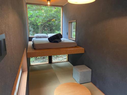 山梨市MEKIKI古民家的小房间设有床和窗户