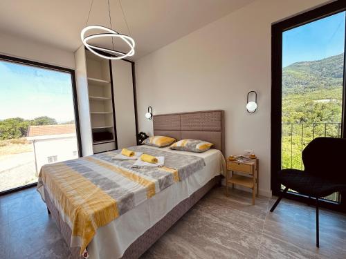 蒂瓦特Adriatic Dream的卧室配有床、椅子和大窗户