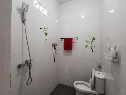 日惹Ambarukmo Green Hill / MA 8的白色的浴室设有卫生间和红色毛巾。