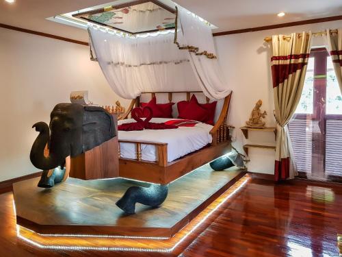 清迈Olivier Boutique的卧室配有一张床铺,地板上放着大象