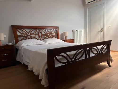 蒙特卡蒂尼泰尔梅Casa Cavour的一间卧室配有一张大木床和白色床单