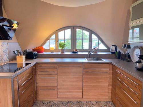 朗克维茨Ferienhaus Mü的厨房配有木制橱柜和拱形窗户