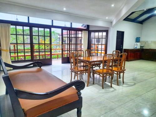 巴图In Villa Garden Resort的一间带桌椅和窗户的用餐室