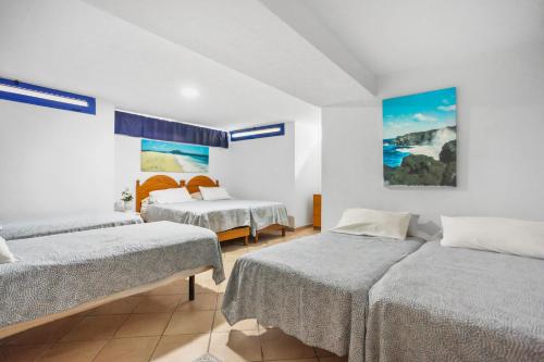 科拉雷侯Villa Mariposas的一间卧室设有两张床,墙上挂着一幅画