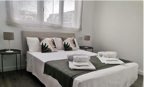 莫特里尔Playa & Golf Deluxe en Playa Granada的卧室配有带毛巾的大型白色床