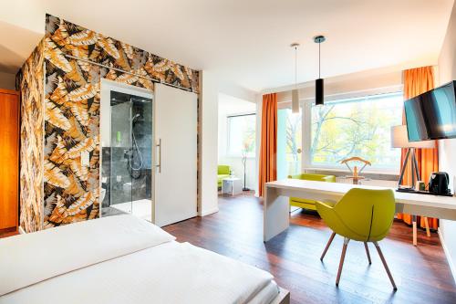柏林卡罗琳彩云之南酒店的酒店客房配有床、书桌和水槽