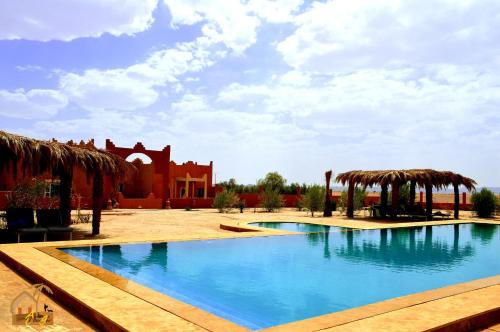 梅尔祖卡Kasbah Du Berger & Piscine的一座大型游泳池,其建筑背景为: