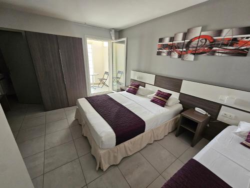 滨海萨纳里Holidays & Work HOTEL的酒店客房设有一张大床和一个阳台。