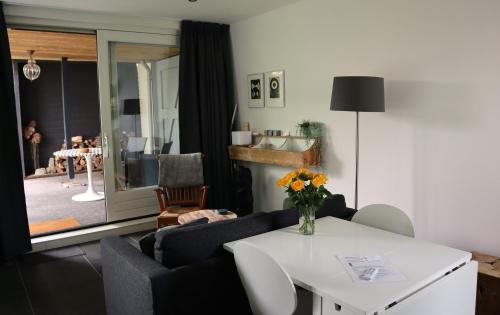 希尔瓦伦比克B & B De Rode Beuk的客厅配有沙发和鲜花桌