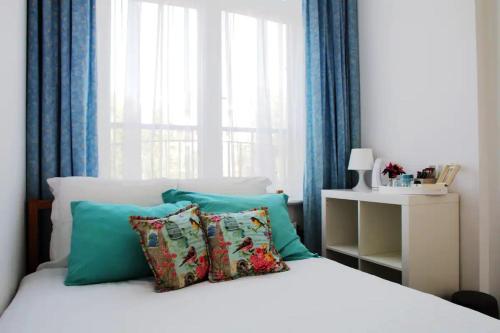 海牙Irene's Palace的卧室配有带枕头的床铺和窗户。