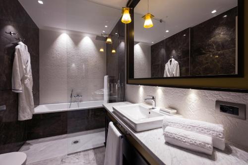 卡利亚里Palazzo Doglio的浴室配有盥洗盆、镜子和浴缸