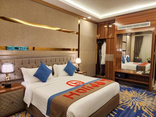 阿可贺巴هوليداي الخليج الخبر Holiday Al Khaleej Hotel的酒店客房配有一张带蓝色枕头的大床