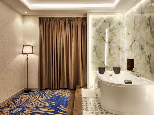 阿可贺巴هوليداي الخليج الخبر Holiday Al Khaleej Hotel的客房内的浴室设有大浴缸