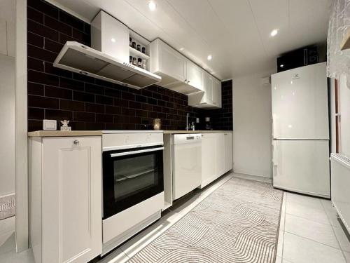 耶夫勒Nyrenoverat boende i villaområde的厨房配有白色家电和黑色瓷砖墙