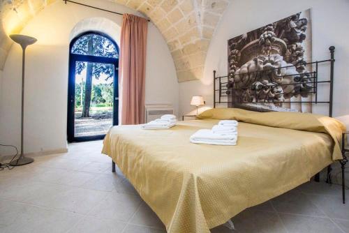 库特罗菲安诺Villa Lucrezio Resort的一间卧室配有一张大床和毛巾