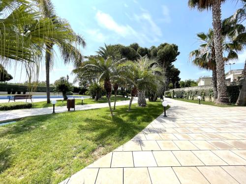 坎布里尔斯LuxuryCambrils Resort&Spa的棕榈树公园和人行道