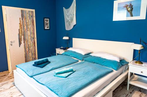 拉肯霍夫Haus-am-Sonnenweg的蓝色卧室配有一张带蓝色床单的大床