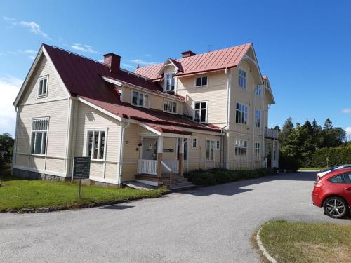 哈诺桑德Sörgårdens Logi的一座大房子,前面有一辆红色的汽车