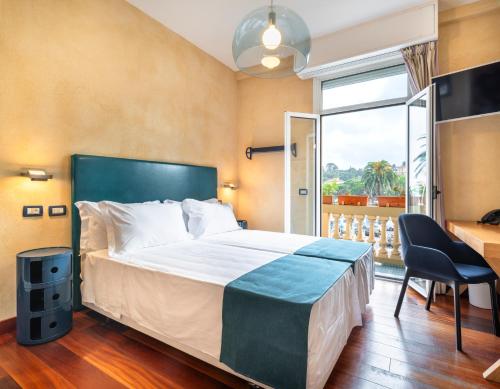 拉帕洛Hotel Rosa Bianca的一间卧室配有一张床、一张书桌和一个窗户。