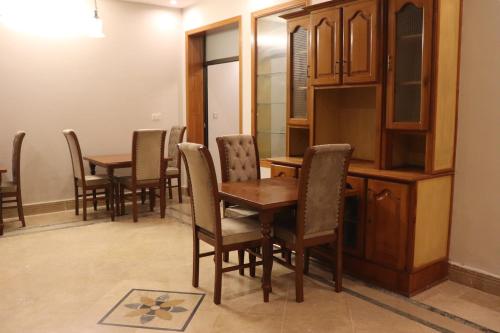 伊斯兰堡Hayat Grand Guest House的用餐室配有木桌和椅子