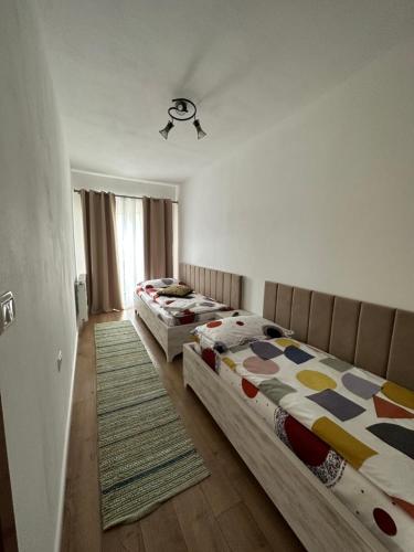 博尔沙CASA IKA&MATEI的一间带两张床的卧室和地毯