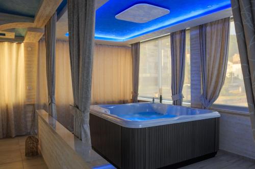 赫尔采格诺维Hotel Maksim的浴室配有蓝色天花板和大浴缸