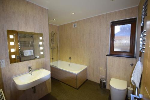 彭里斯Aikbeck Lodge的一间带水槽、浴缸和卫生间的浴室