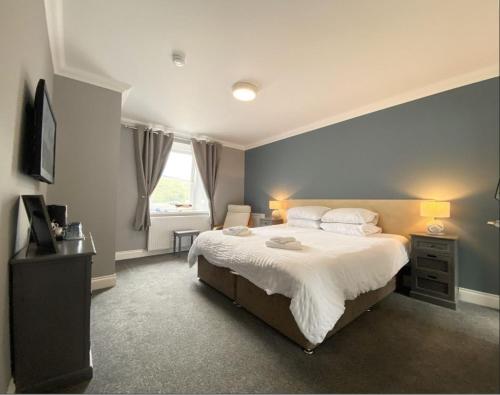 Garelochhead安卡尔宾馆的一间卧室设有一张蓝色墙壁的大床