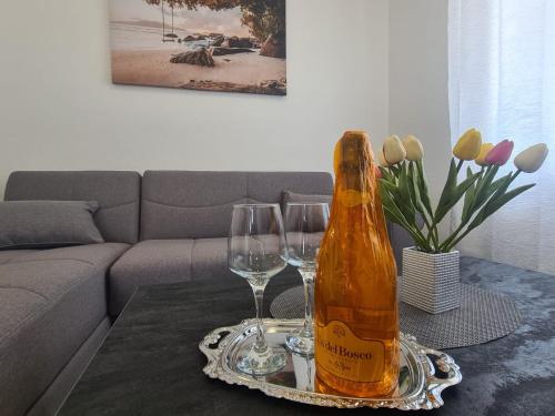 卡什泰拉Lady Di apartments的桌子上放有一瓶香槟和两杯酒杯