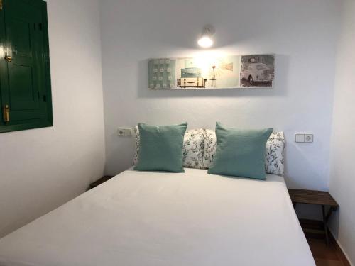 圣弗朗西斯科哈维尔Viviendas Ferrer - Can Joan Andrauet的一间卧室配有白色床和蓝色枕头