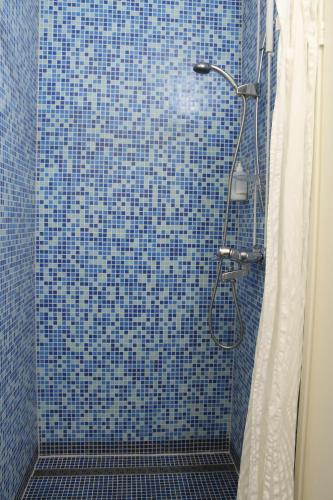 科特卡Budget apartment in Kotka # 16的浴室内设有带浴帘的蓝色瓷砖淋浴间
